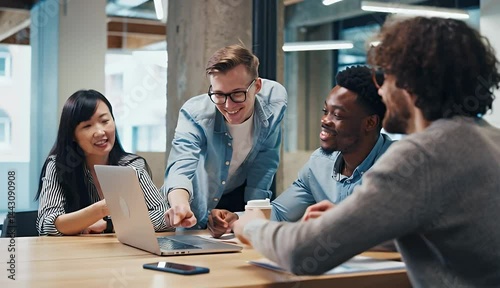 Office workers discussing a project on a laptop