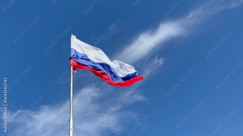 Russian flag fluttering in the wind view from below against blue sky Russian flag fluttering in the wind view from below against blue sky