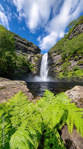 Cascading waterfall framed by lush greenery, a vibrant natural scene under a partly cloudy sky