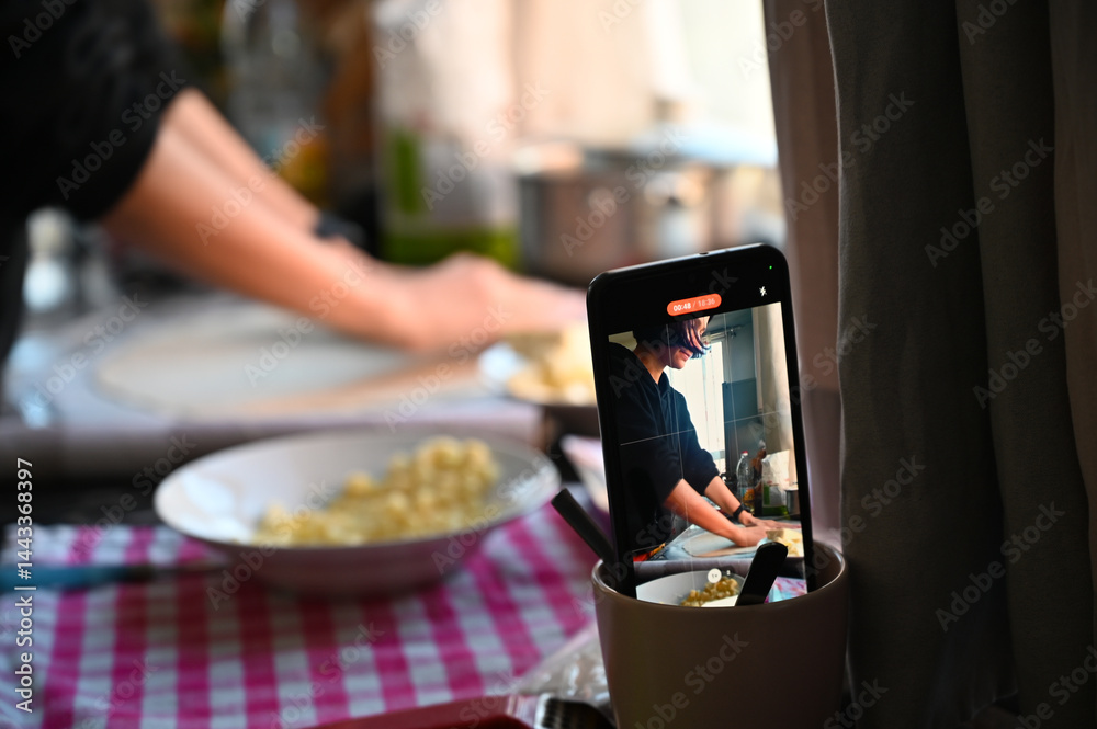 Filming on a phone as a girl cooks pizza. Home shooting. Video content for social networks.