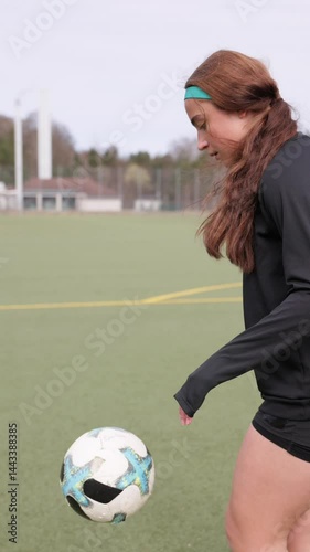 Girl kicking a ball on a soccer field. Football training. Football.
