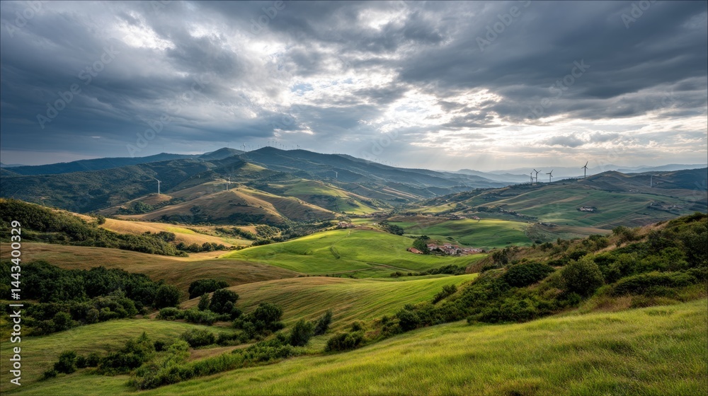 Naklejka premium Scenic mountain valley landscape with rolling hills, pastures, and wind turbines
