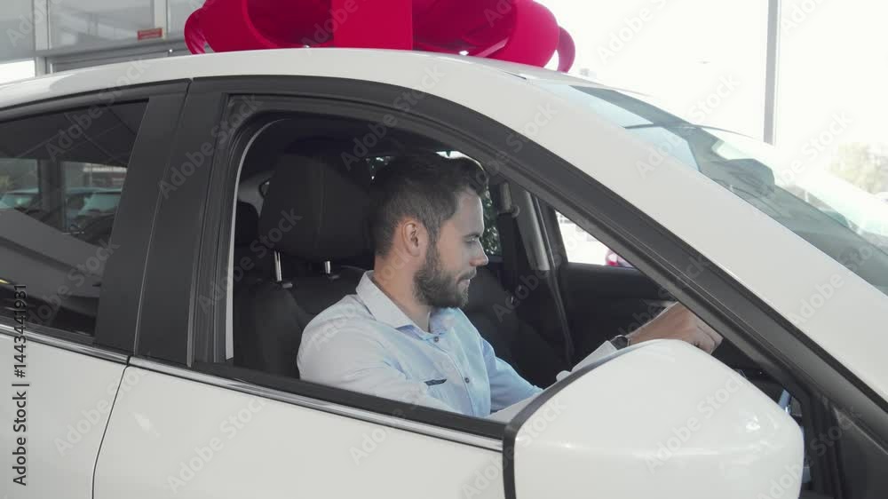 Cheerful man proudly displaying car keys in his new vehicle at the dealership Cheerful man proudly displaying car keys in his new vehicle at the dealership