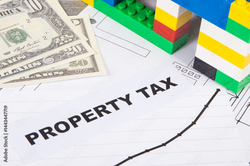 House made of toy blocks, dollar banknotes and rising graph showing real estate taxation increases. Calculating and paying tax House made of toy blocks, dollar banknotes and rising graph showing real estate taxation increases. Calculating and paying tax