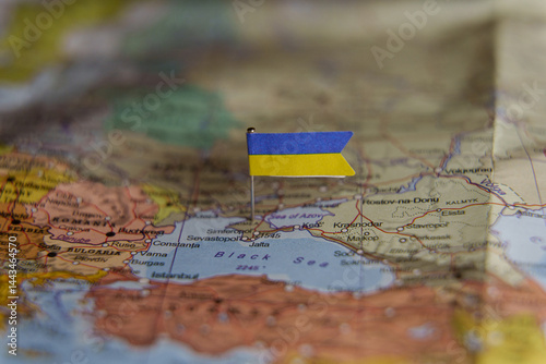 Ukrainian flag pinned on a map focusing on Crimea and the Black Sea region, symbolizing conflict and territorial dispute