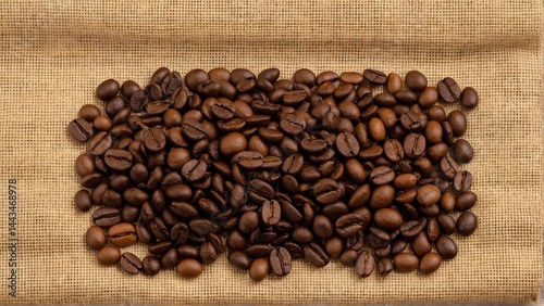 Aromatic Treasure: Roasted Coffee Beans Cascading Over Rustic Burlap, Inviting Warmth and the Promise of a Perfect Brew.