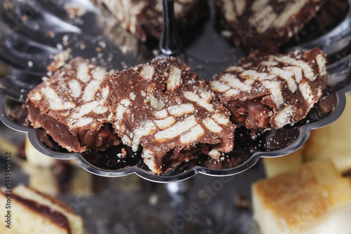 Obraz na płótnie Chocolate biscuit dessert. Sweet layered treat. Homemade cocoa slices. Crunchy cookie mix. Holiday snack idea. Rich chocolate flavor. Dessert buffet detail. Delicious rustic cake piece. w salonie