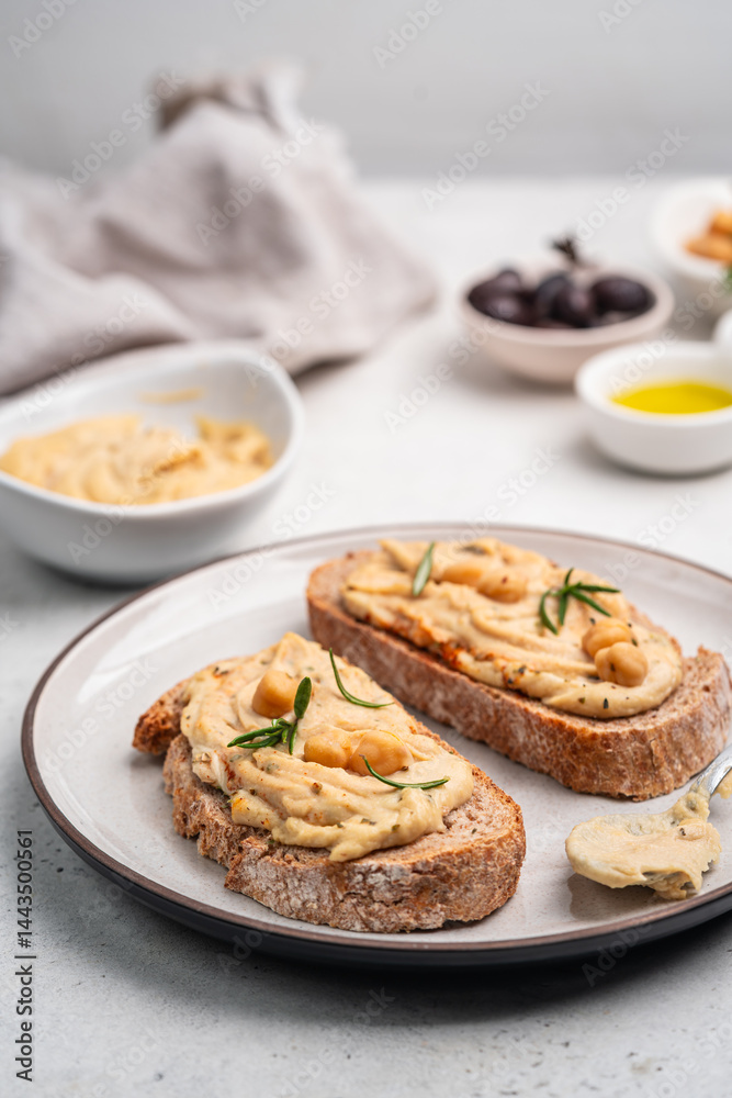Delicious sandwiches with hummus and ingredients on white table, flat lay. High quality photo