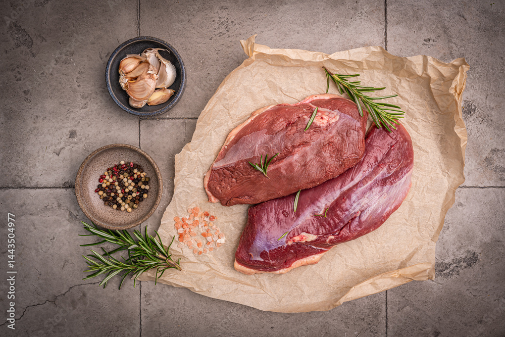 Preparation for cooking raw duck breast with ingredients on dark background, top view. Space for text. High quality photo