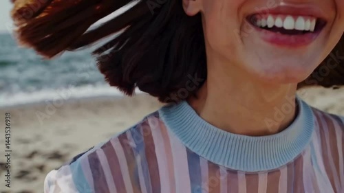 Laughing woman at beach with wet hair and striped top