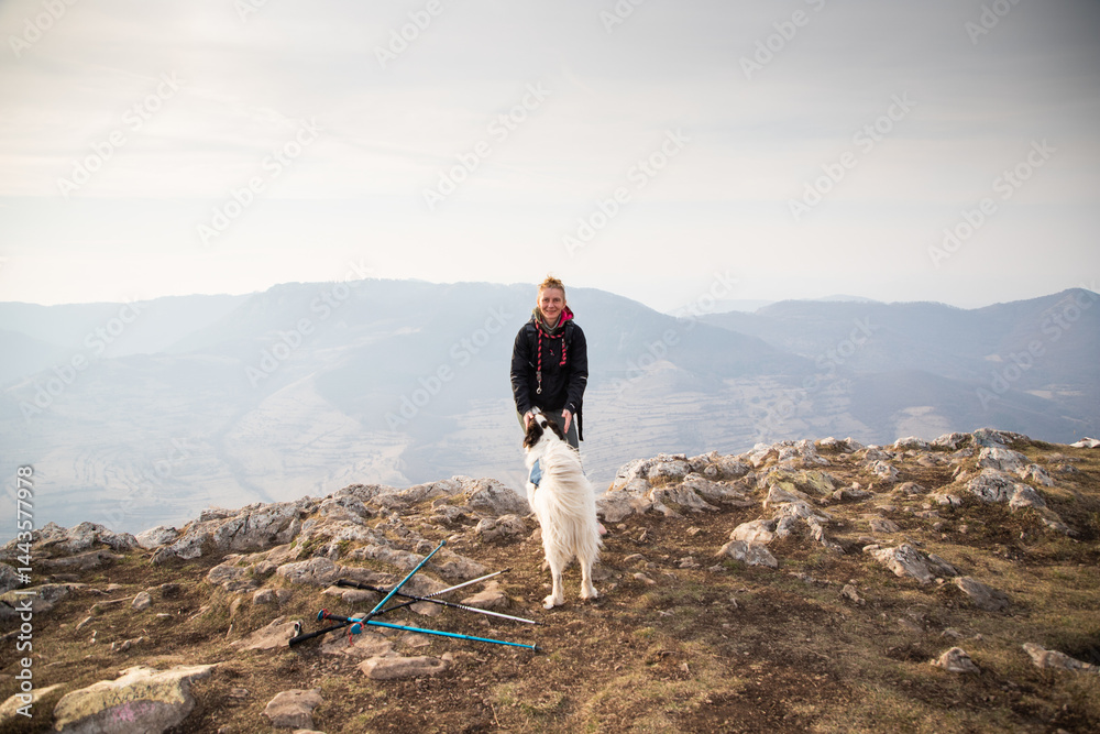 happy fit woman trekking with her dog