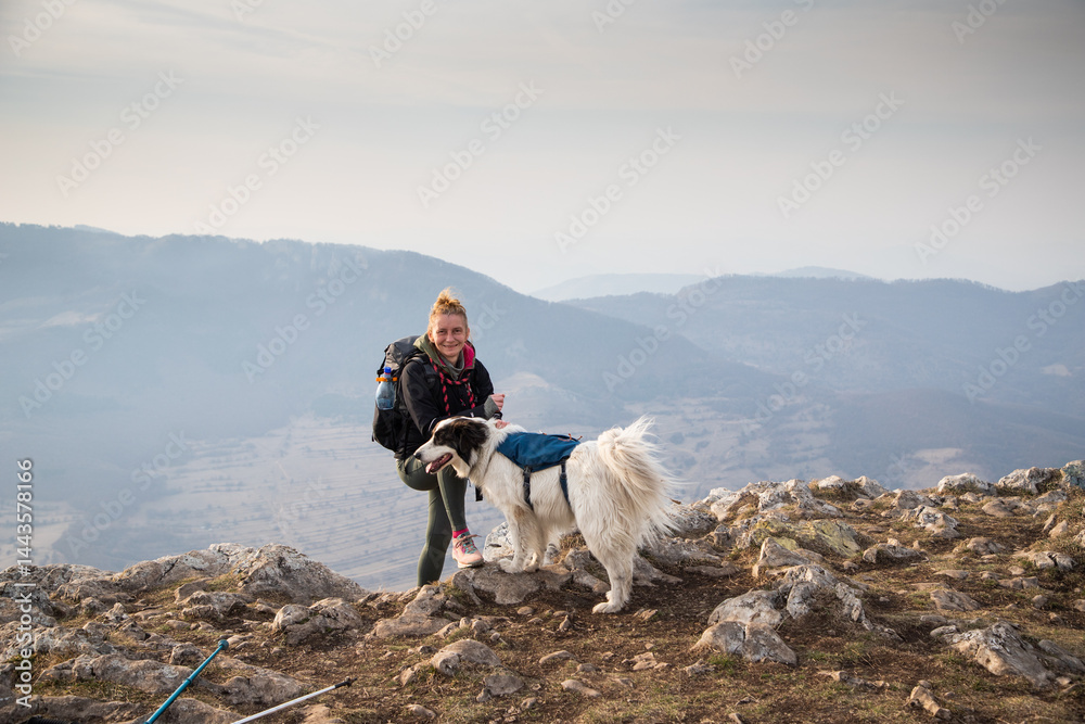 happy fit woman trekking with her dog