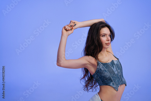 Young woman stretching gracefully against a solid blue background