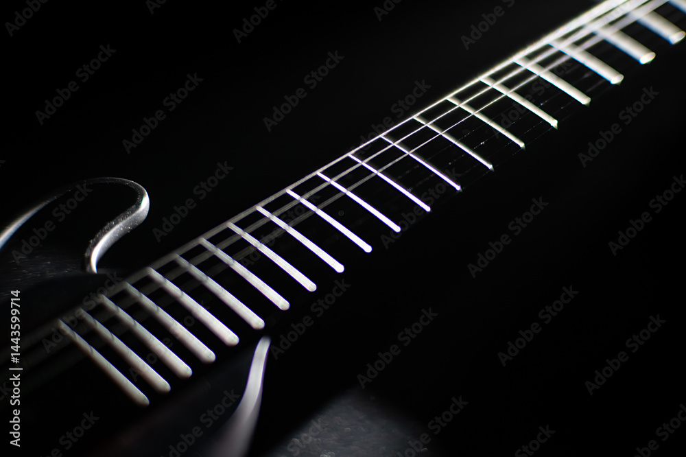Fototapeta premium Close-up of an electric guitar, emphasizing illuminated metal frets against a dark background Shallow depth of field photography style