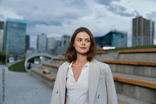 Confident woman in business attire standing outdoors, showcasing modern cityscape in the background, embodying empowerment and professionalism.
