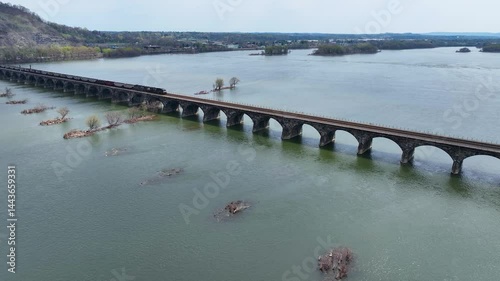 Stunning 4K aerial drone footage of the historic Rockville Bridge stretching across the Susquehanna River near Harrisburg, Pennsylvania. Captured from a high vantage point, this breathtaking view