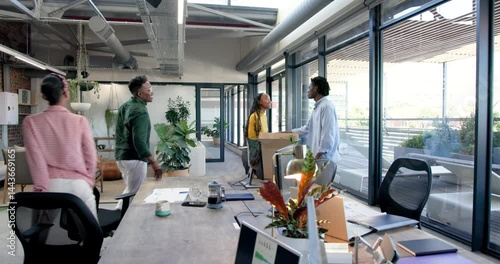 Wallpaper Mural African American coworkers celebrating project success in modern open-plan office, with data charts Torontodigital.ca