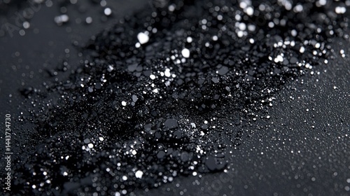 Black granular substance with white speckles, macro