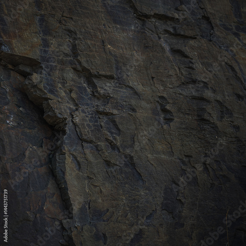 A textured stone background with chiaroscuro lighting, showcasing a brutal, monolithic rock formation. Cracks and fragments highlight its geological power, perfect for design templates or science