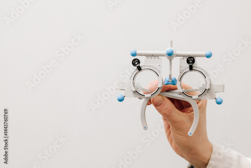 Trial frame glasses in ophthalmologist hands on white background. Trial glasses frame eye visual system of people with short or long power vision.