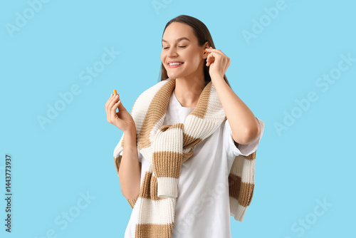 Young woman putting ear plu...