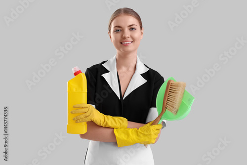 Young housemaid with cleani...