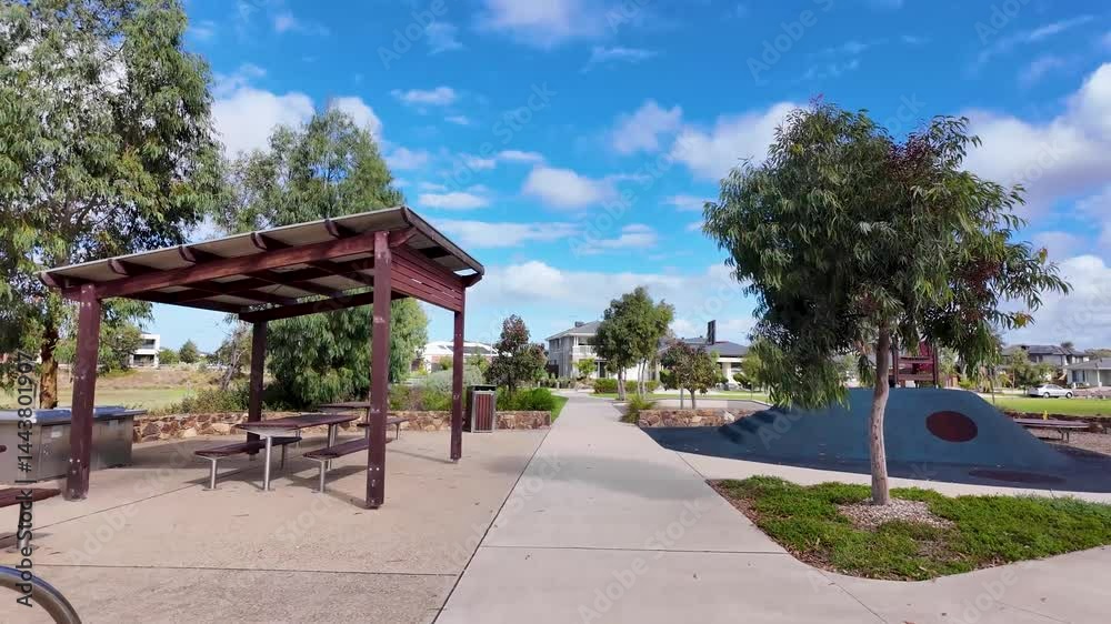A suburban community park in Melbourne, Australia features a sheltered picnic benches and barbeque station, bike racks, a playground mound, sports ground and paths surrounded by newly built houses A suburban community park in Melbourne, Australia features a sheltered picnic benches and barbeque station, bike racks, a playground mound, sports ground and paths surrounded by newly built houses