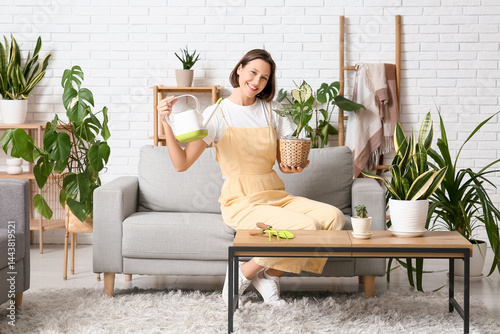Smiling woman watering hous...