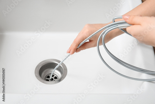 Woman cleaning drain with p...