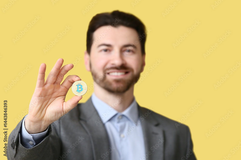 Businessman with bitcoin on yellow background, closeup Businessman with bitcoin on yellow background, closeup