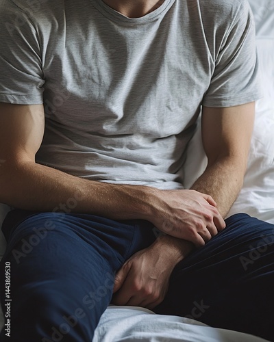 Man Seated in Light Gray T-Shirt and Dark Blue Pants