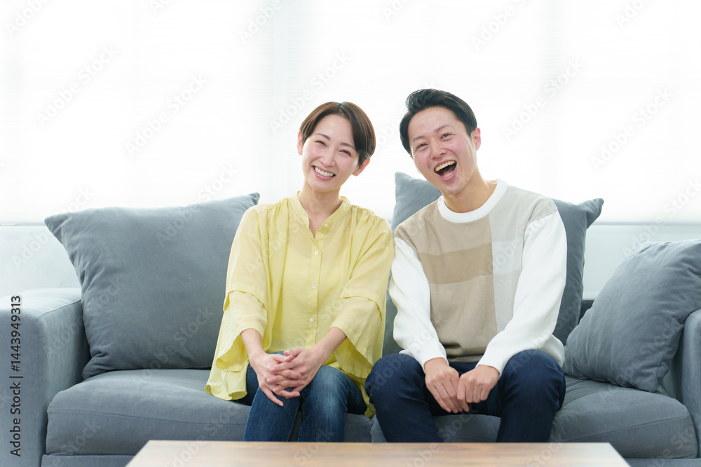 ソファーでリラックスする若い夫婦