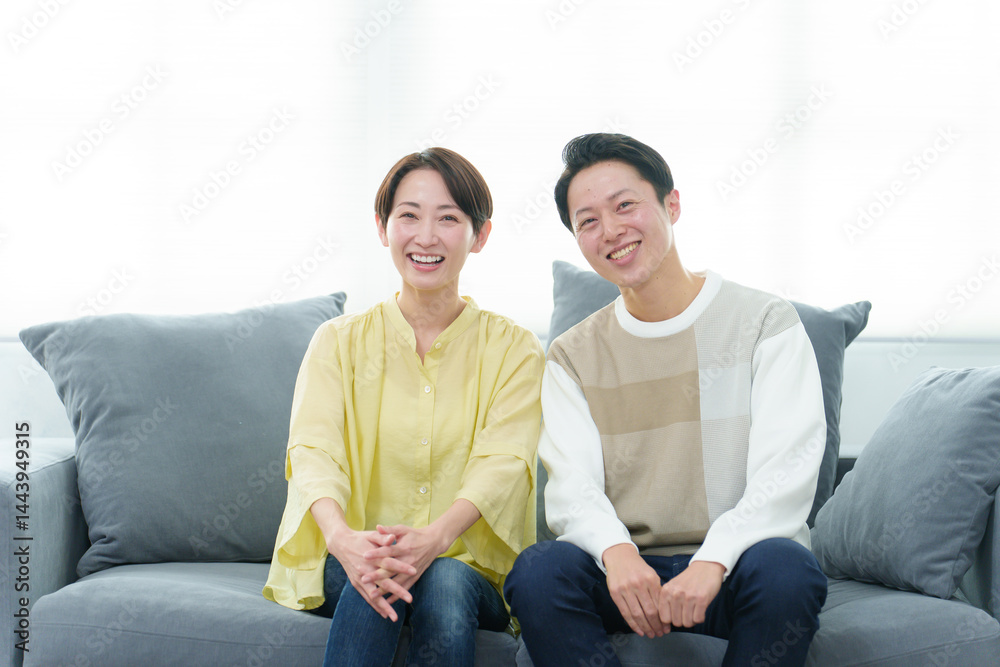 ソファーでリラックスする若い夫婦