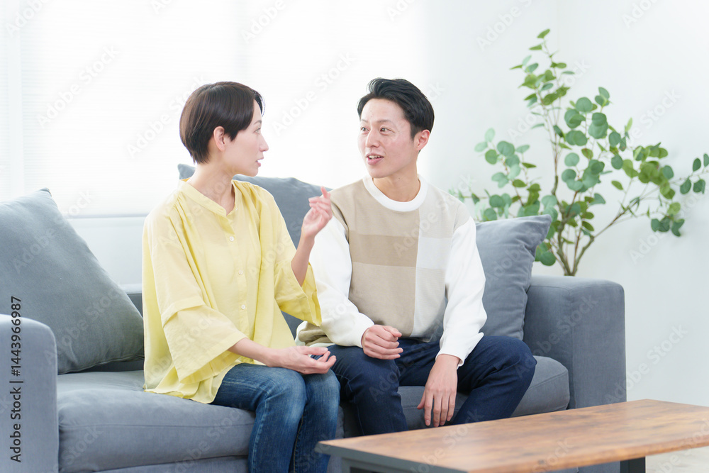 リビングで雑談をする若い夫婦