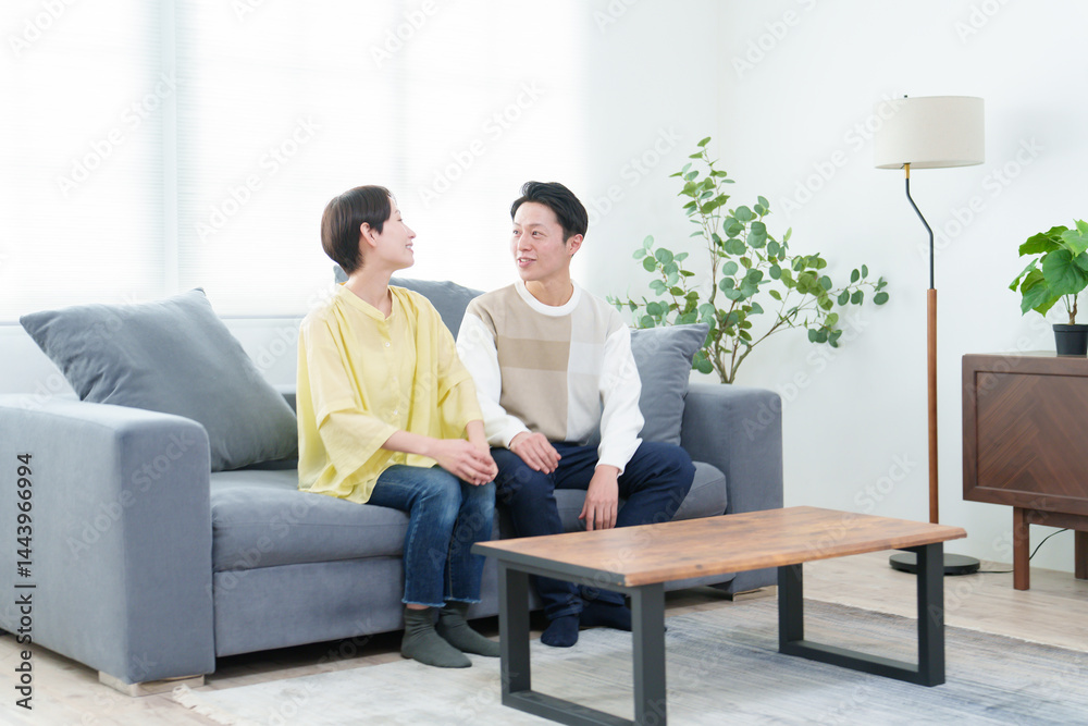 リビングで雑談をする若い夫婦