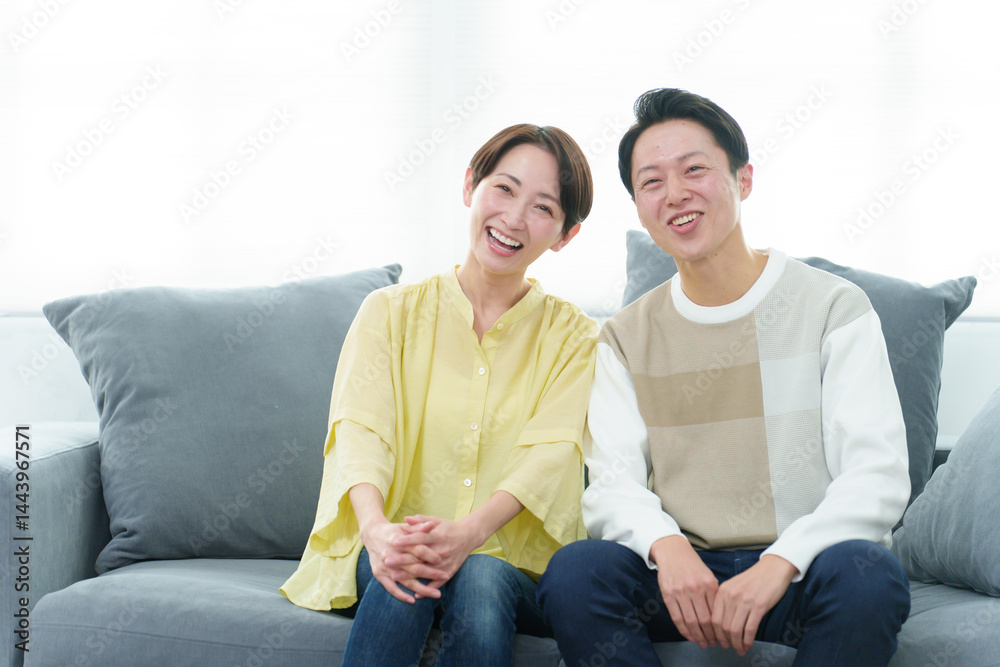 リビングでテレビを見る若い夫婦