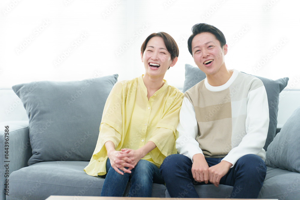 リビングでテレビを見る若い夫婦