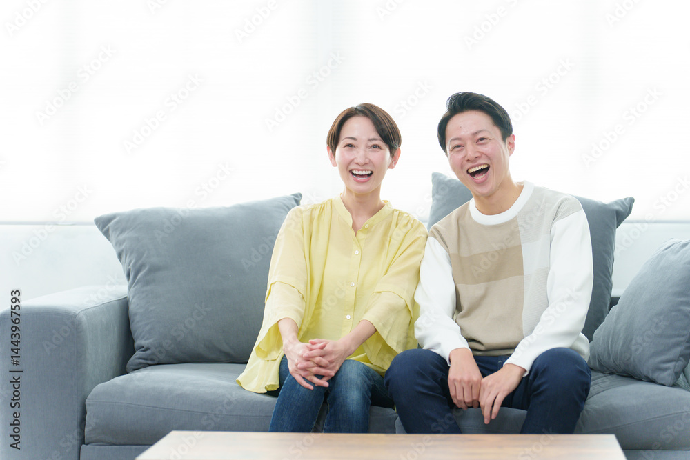 リビングでテレビを見る若い夫婦