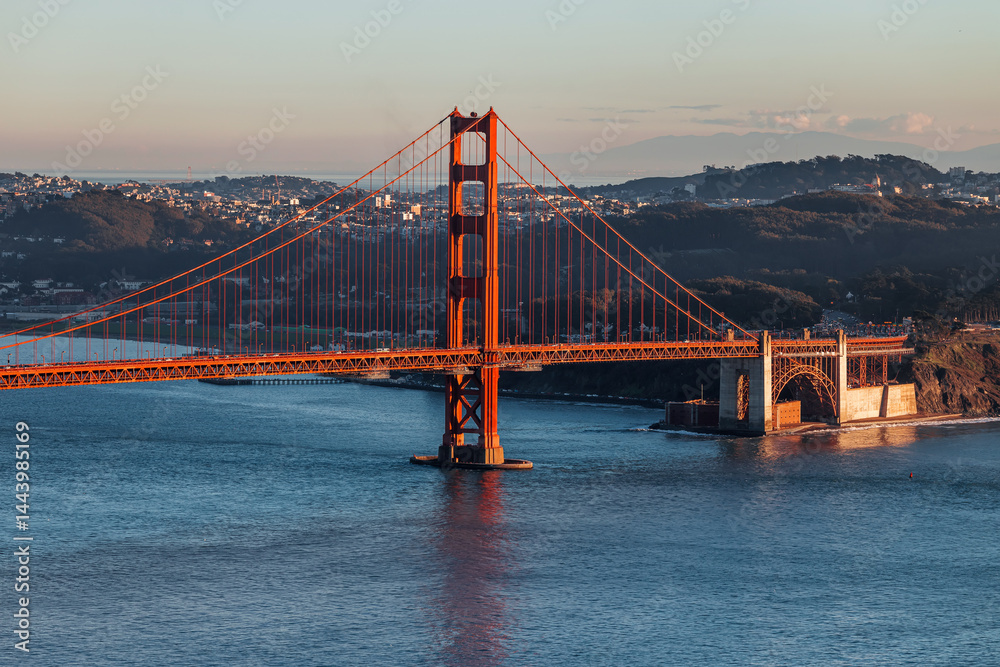 Fototapeta premium Golden Gate Bridge stands prominently at sunset overlooking San Francisco Bay