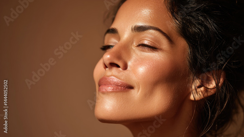 Radiant woman with healthy, glowing skin.  Soft, warm light highlights facial features, conveying a sense of well-being and natural beauty