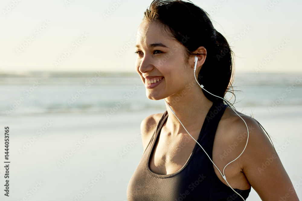 Fototapeta premium Fitness, beach and mockup with woman smile for running, workout and summer goal with music. Athlete, earphones and ready to start jog for exercise, endurance or health for wellness sport training