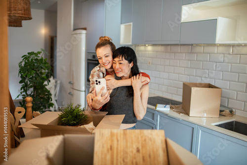 Happy lesbian couple embracing in new home while moving in
