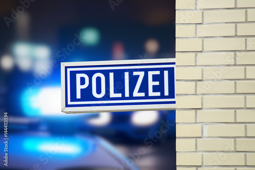 Polizeiwache in Deutschland und Polizeiautos mit Blaulicht im Hintergrund photo