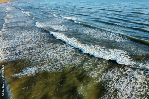 Aerial shot capturing the contrast between dark ocean waves and bright white seafoam, prince edward island Canada. High quality photo