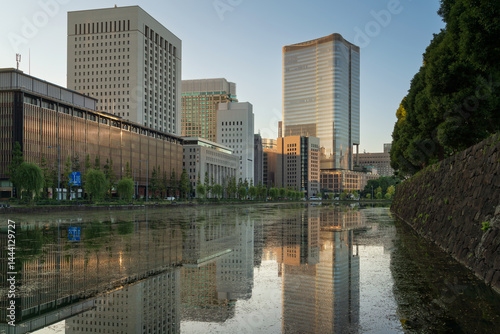 View of Hibiya-bori moat, the Outer Gardens of the Imperial Palace and the Tokyo Midtown Hibiya skyscraper in Yurakucho business district of Chiyoda City on a sunny morning, Tokyo, Japan