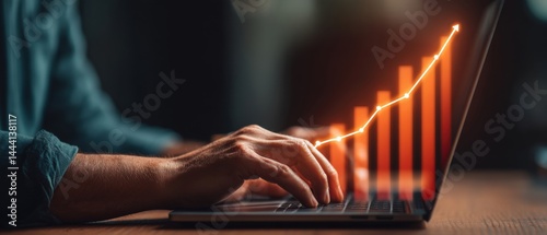 Obraz na płótnie A hand typing on a laptop with a rising graph displayed, symbolizing growth and progress in business or finance. w salonie