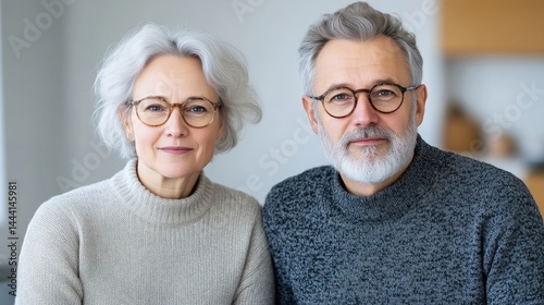 Mature Couple Glasses Neutral Style High-resolution Soft Lighting Portrait Close-up Shot Calm Demeanor Home Setting Soft Gray Tones Ideal for Healthcare Ads
