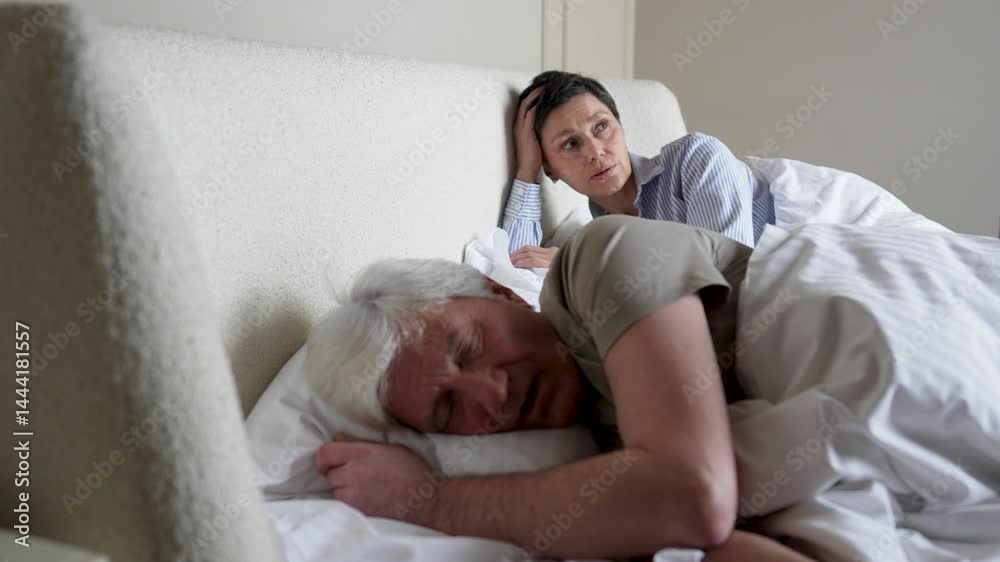 Irritated sleep deprived wife pushes snoring husband back in bed. Sleep deprivation, nasal issue, restless night and shared bed struggle, frustrated exhausted woman, marriage tension, insomnia cause