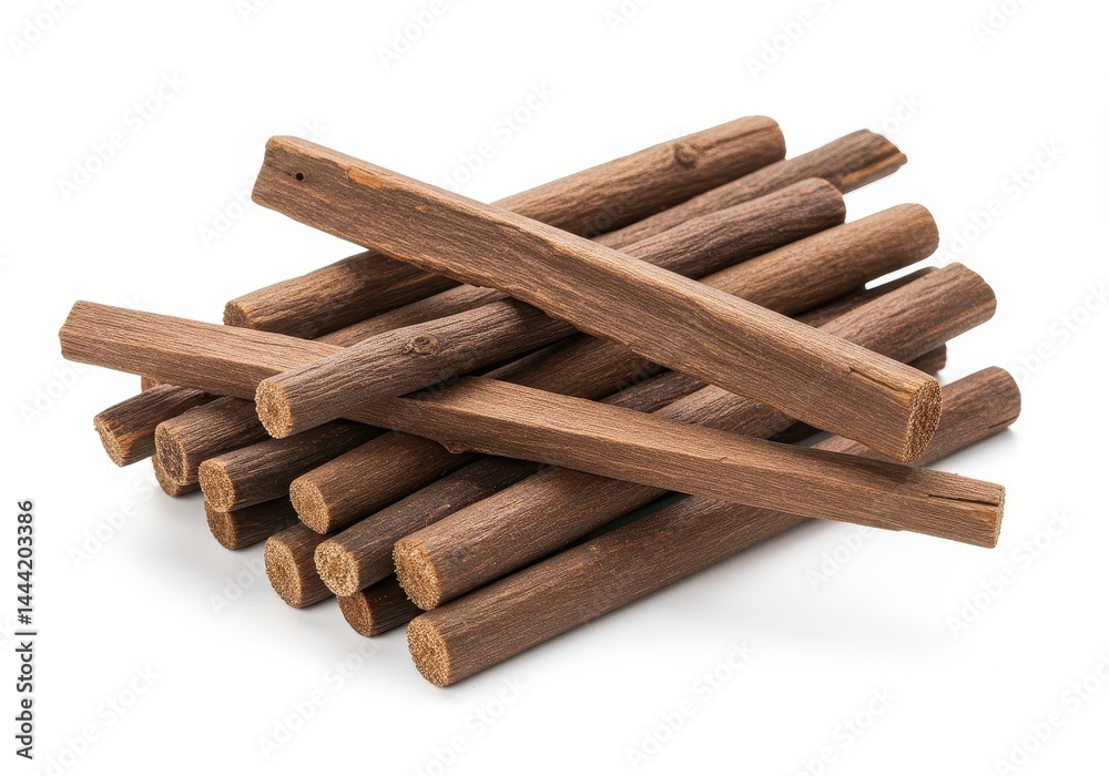 A pile of brown wooden sticks arranged in a stacked manner on a white surface in a studio shot