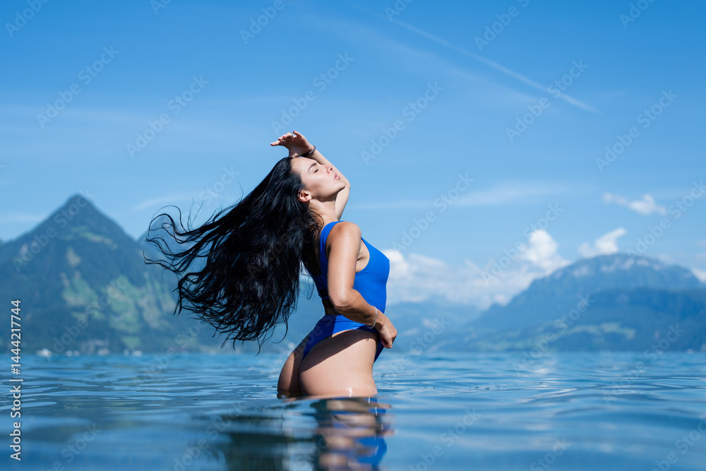 Naklejka premium Sexy model on nature at summer vacation. Beautiful girl in a swimsuit posing sexy in the water. Sexy tanned body, perfect figure. Exotic country travel and rest concept. Slim figure and sexy body.